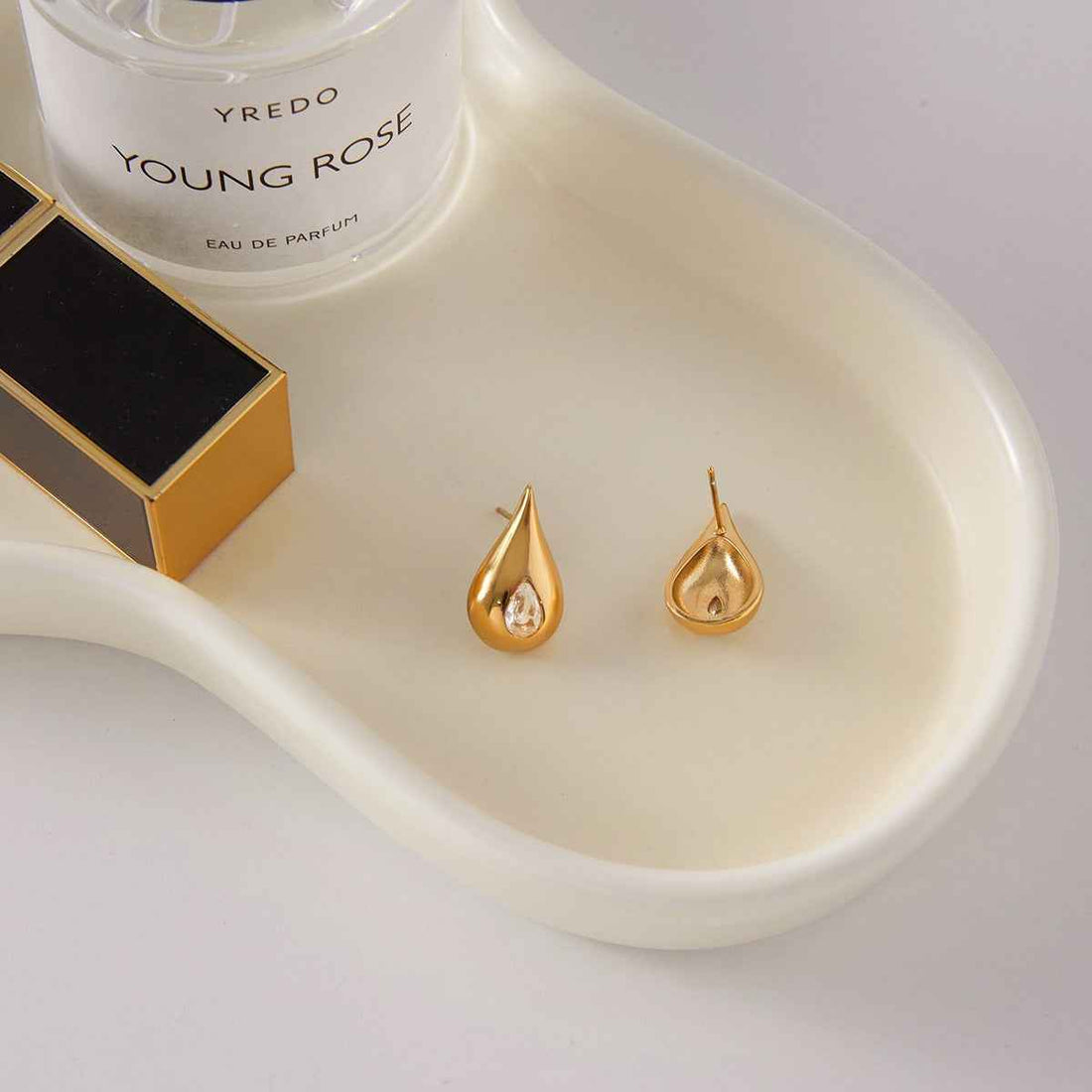 18K gold earrings inlaid with cubic zirconia in a teardrop design.