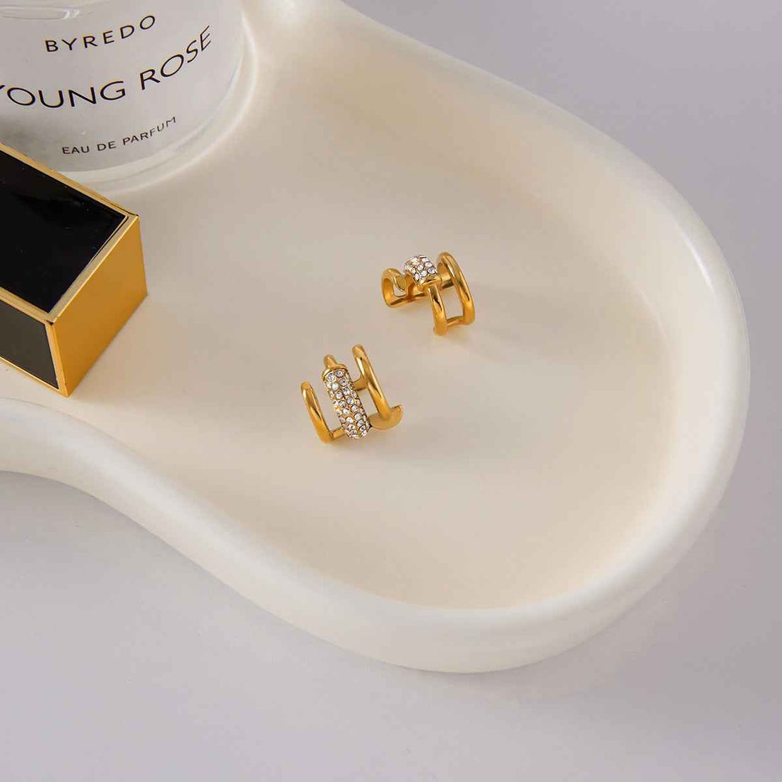 18K gold earrings inlaid with cubic zirconia, in a nail design.