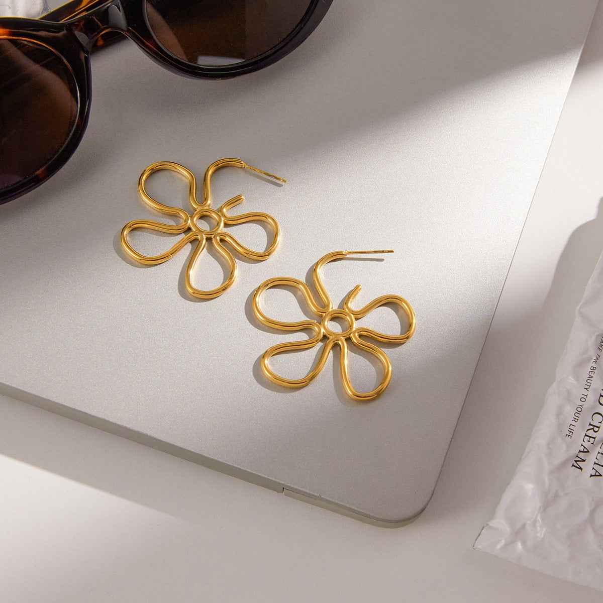 18K gold-plated, lightweight, and luxurious flower-shaped titanium steel earrings.