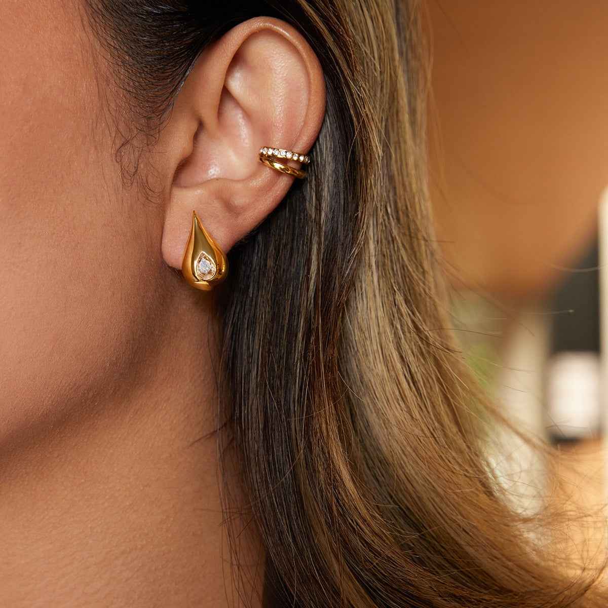 18K gold earrings inlaid with cubic zirconia in a teardrop design.