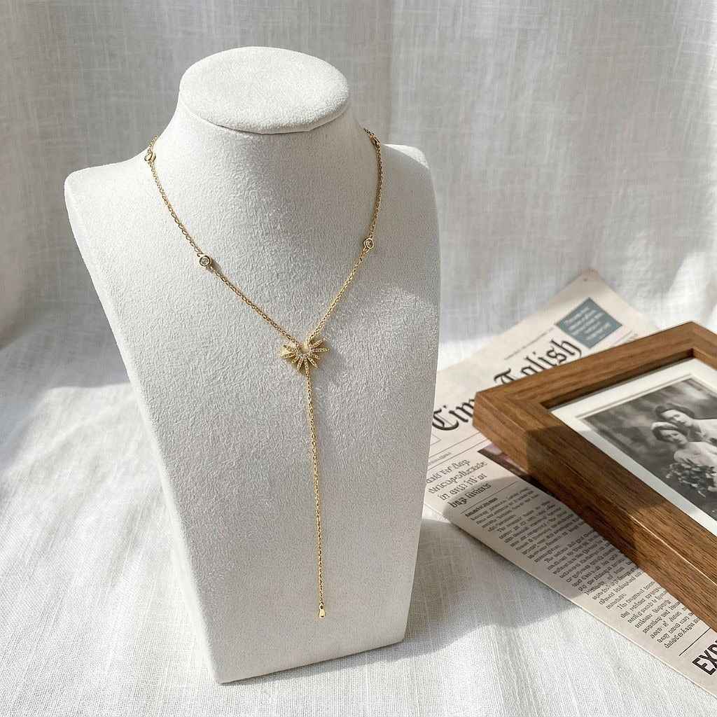 18K gold Y-shaped lasso necklace with diamond-encrusted sunflower and snowflake pendant.